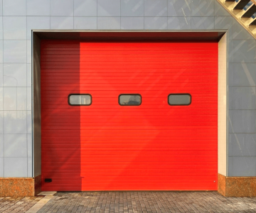 A brick house with a red garage door.