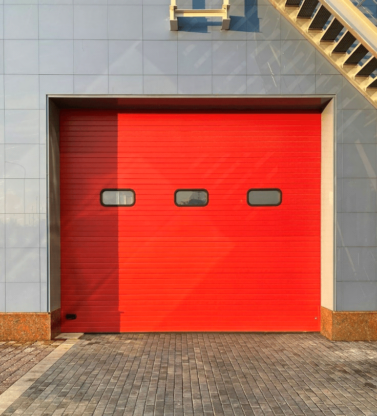 A brick house with a red garage door.