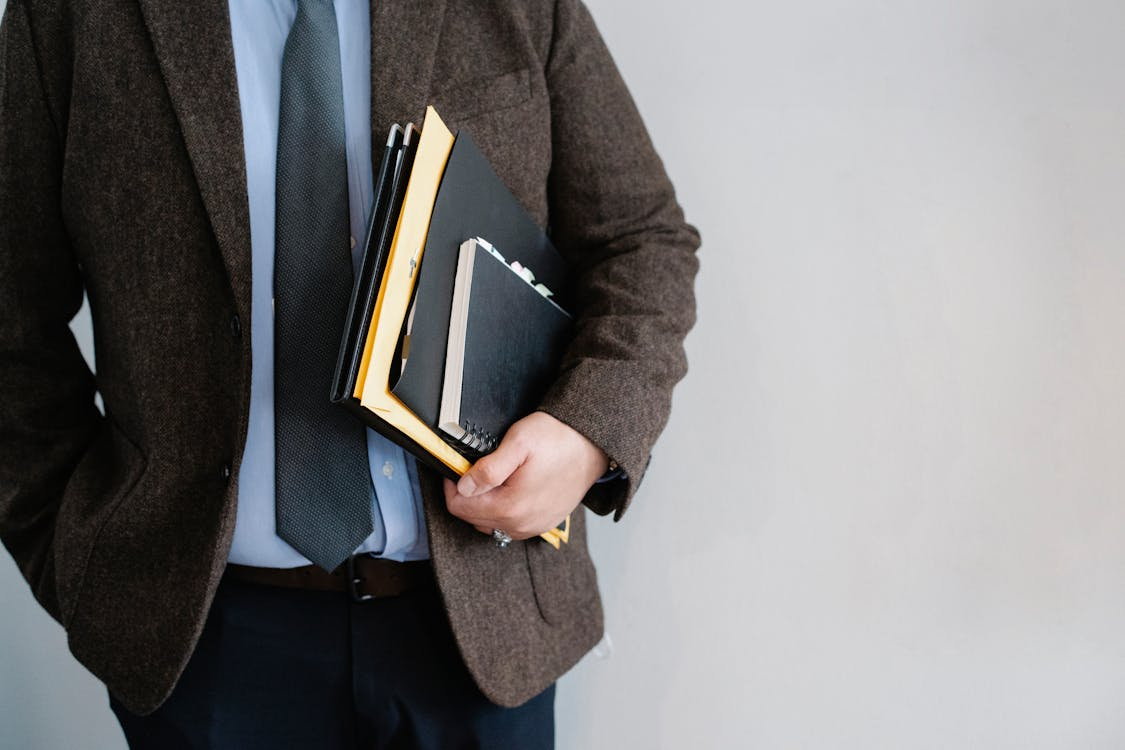  An unrecognizable office employee standing and holding documents