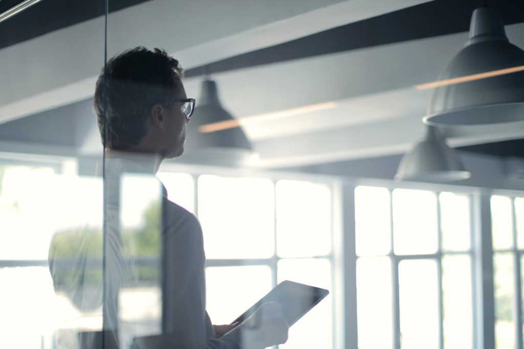 A man holding a tablet while presenting at work